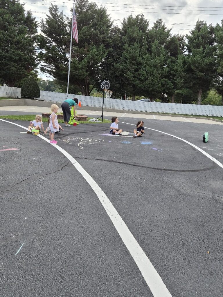 Primary students drawing with sidewalk chalk