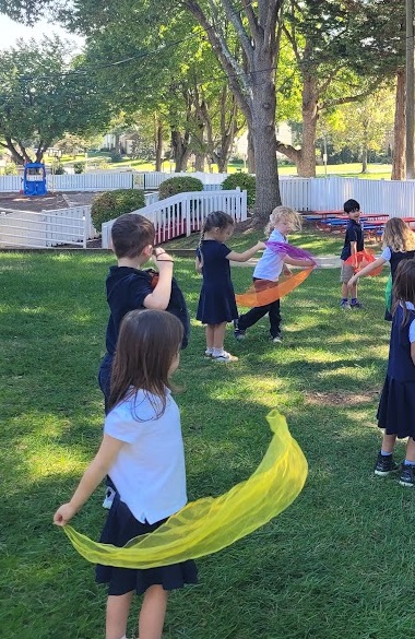 Primary students playing outside with scarves